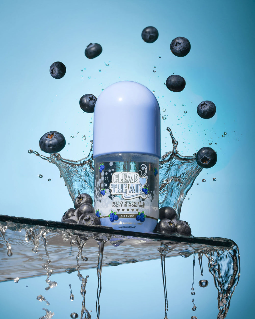 Üveg P. Louise Clear The Air Blueberry Gel Cleanserl áfonyával és vízfröccsenéssel körülvéve, kék alapon