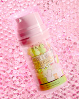 Egy üveg P.Louise Here I Glow Again Recovery Mask Candy Bears illatú, rózsaszín és zöld címkével, cukorka medvék illusztrációival, rózsaszín csillogó háttérrel.
