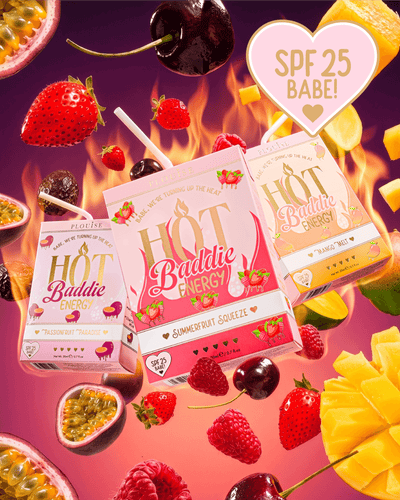A Hot Baddie Energy SPF Lip Conditioner és Lip Oil Duo három gyümölcsleves doboza dinamikusan lebegő kompozícióban van elrendezve, friss gyümölcsszeletekkel, cseresznyével, eperrel és maracujakkal körülvéve élénk rózsaszín és narancssárga háttéren, lánggrafikával. 
