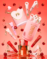 Pink XL Protect Your Pout ajándék szett, amelyet meggy, valamint rózsaszín és piros ajakkondicionálók vesznek körül rózsaszín alapon.