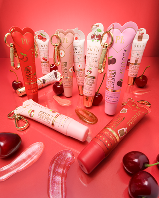 Collection of pink and red cherry protect your pout lip conditioners with swatches and cherries placed around them against a red background