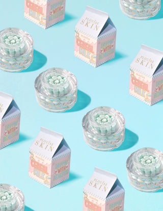 A P.Louise Dose of Dreams C-vitamin kapszula krém átlátszó tartályai kék kapszulával, tejesdobozokkal körülvéve