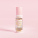 Rózsaszín spray-palack „P.Louise SKIN” felirattal, szívet és néhány virágos elemet ábrázolva, hidratáló kötő spray-vel.