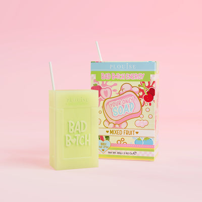 Zöld szappan, amelyen „Bad Bitch” felirat van gravírozva, és egy színes gyümölcslédoboz-csomag, amelyen „Mixed Fruit” felirat szerepel, rózsaszín alapon.