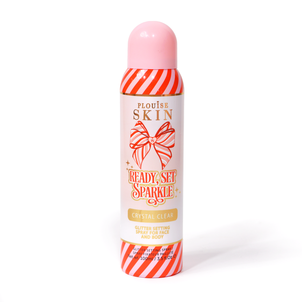 Egy üveg P. Louise Ready Set Sparkle Christmas Glitter Setting Spray piros és rózsaszín csíkokkal az üvegen, valamint piros és rózsaszín csíkos masnival fehér háttér előtt