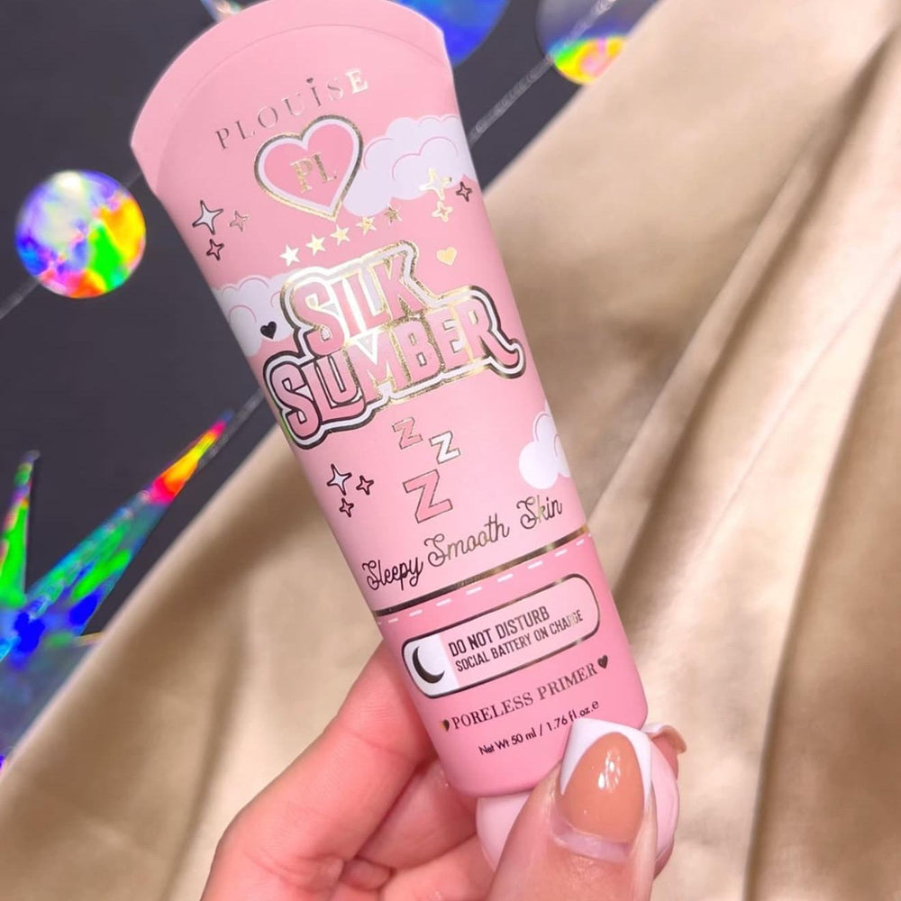 Egy személy kezében egy tubus P.Louise Silk Slumber Poreless Primerrel, rózsaszín háttérrel és kozmetikai termék részleteivel.