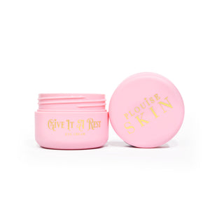 Rózsaszín nyitott üveg P.Louise Give It A Rest Eye Cream, amelyen a fedél és a tégely oldalról látható, az üvegen arany betűkkel a márkajelzés és a terméknév